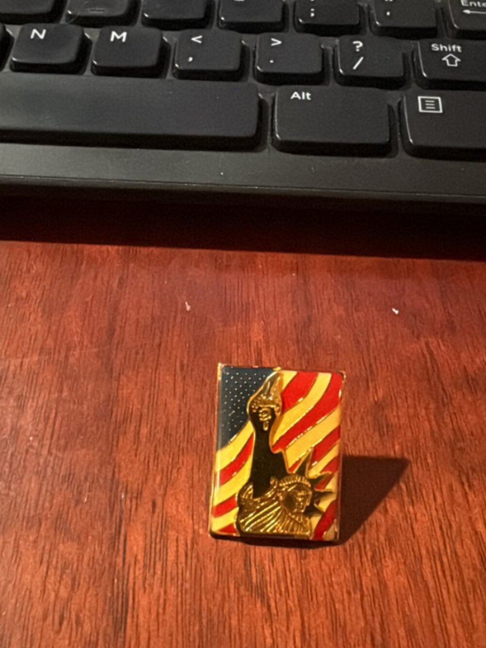 Statue of Liberty pin with an American flag background